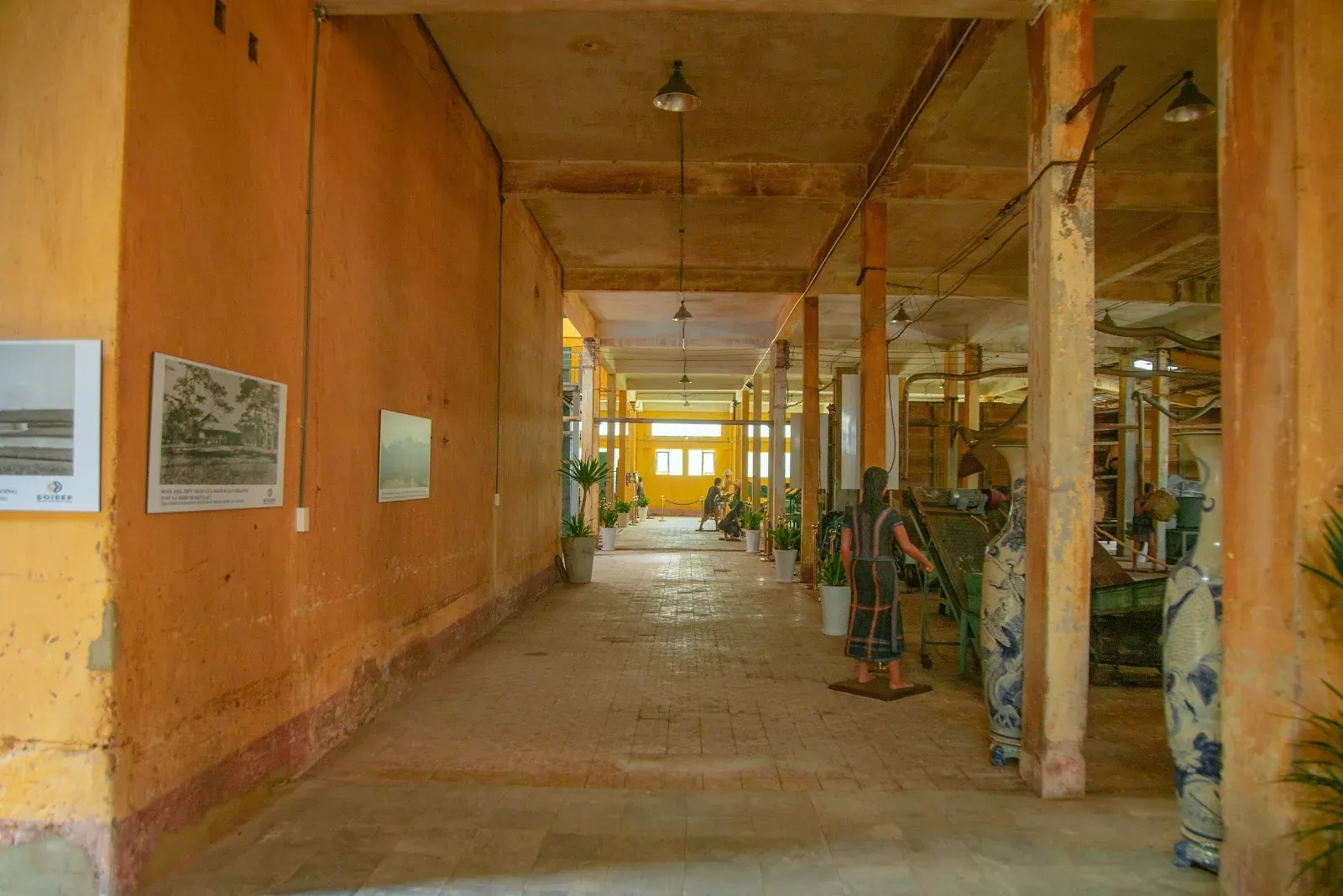 A corridor inside the 1927 Tea Factory with golden walls and tea-making photographs